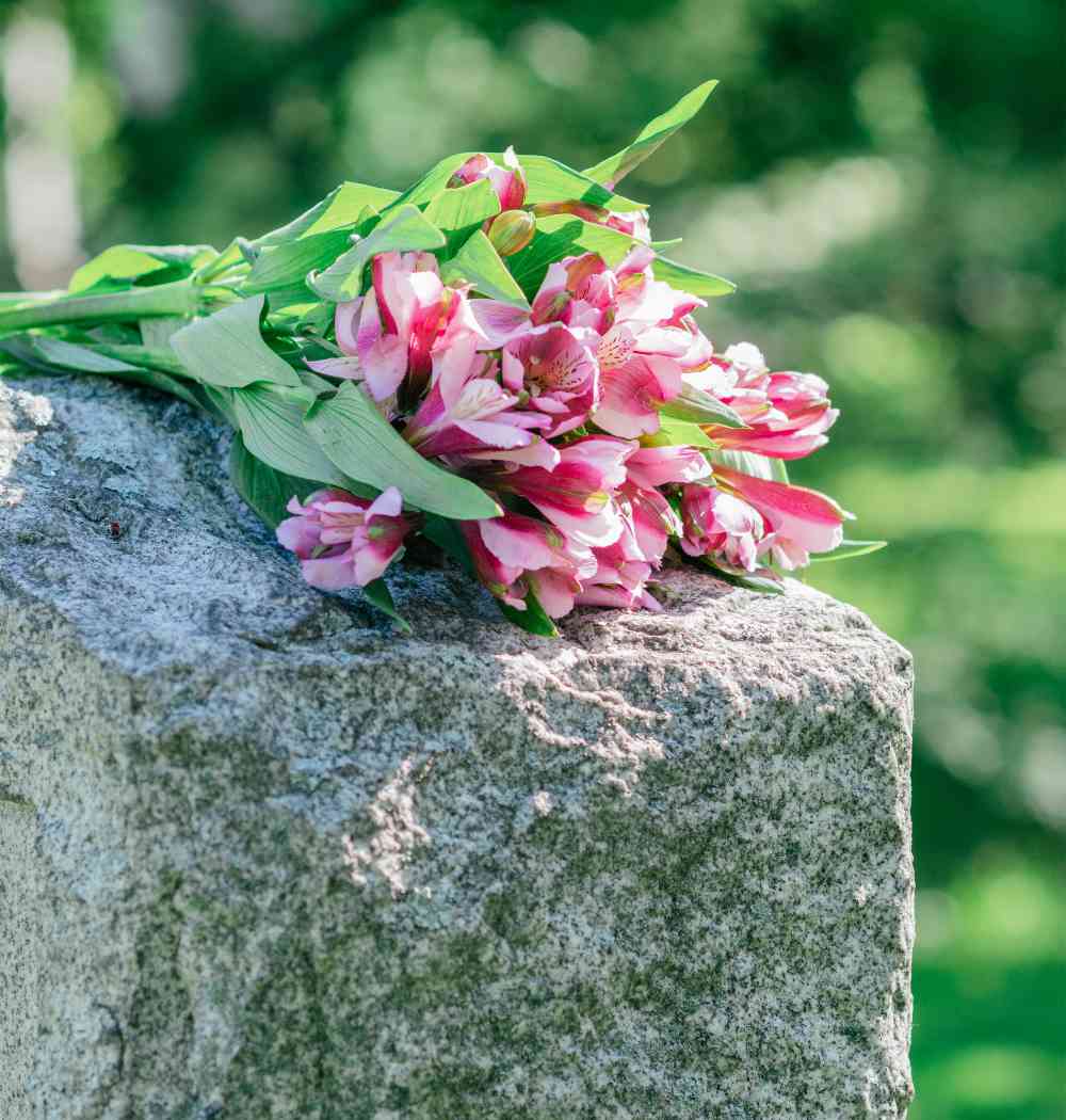 A monument with pink flowers displayed on top.